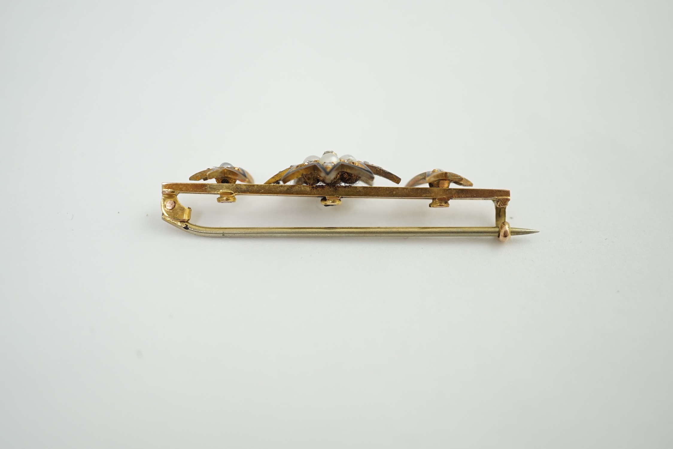 A cased Victorian gold, enamel, rose cut diamond and split pearl set bar brooch